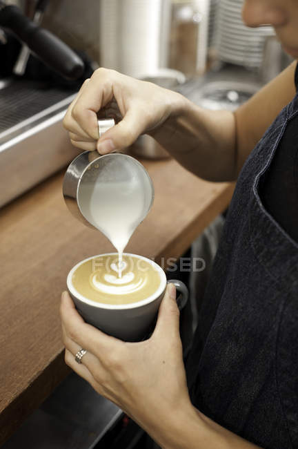 Abgeschnittenes Bild eines Barista beim Cappuccino zubereiten — Stockfoto