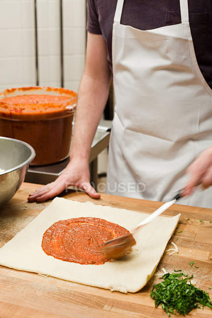 Чоловічий шеф-кухар робить піцу на комерційній кухні — стокове фото