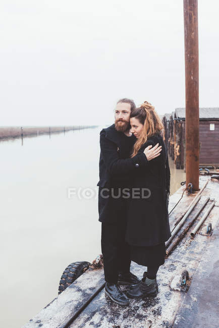 Coppia abbracci sul lungomare del canale nebbioso — Foto stock