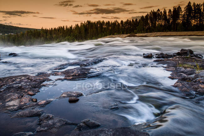 Río que fluye sobre rocas, Storforsen, Laponia, Suecia - foto de stock