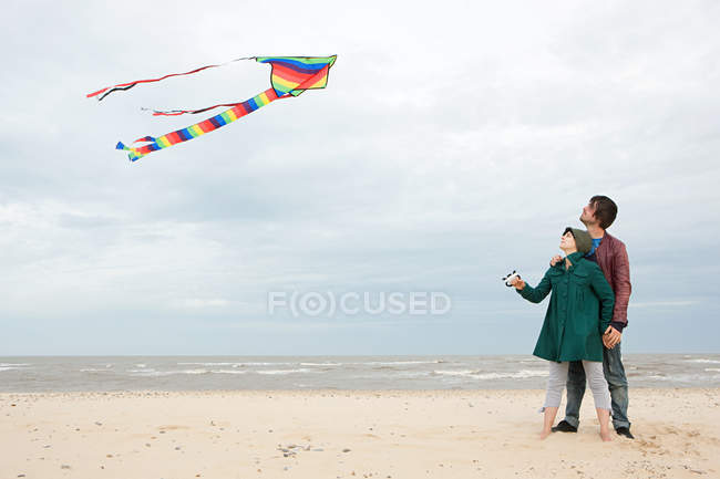 Jeune couple avec cerf-volant près de la mer — Photo de stock