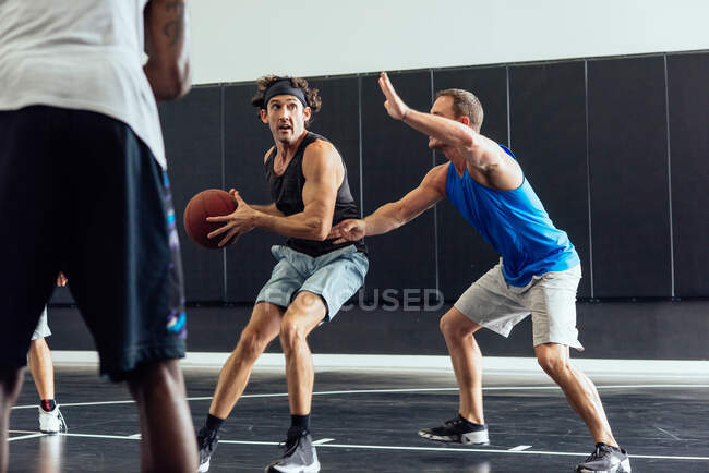 Jogadores de basquete masculino defendendo bola no jogo de basquete — Fotografia de Stock