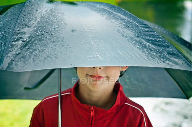 Мальчик под зонтиком — стоковое фото