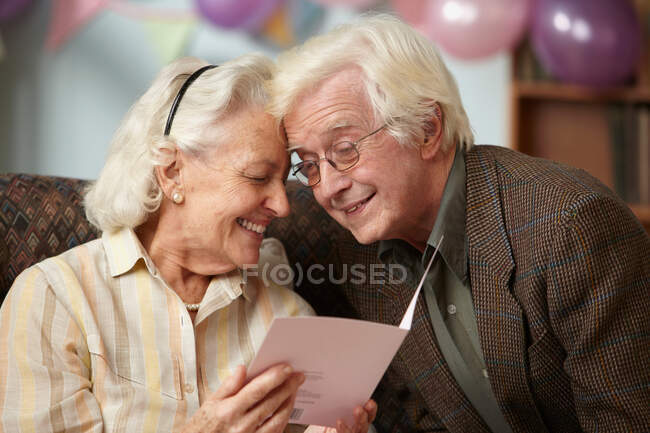 Seniorenpaar liest Geburtstagskarte — Stockfoto