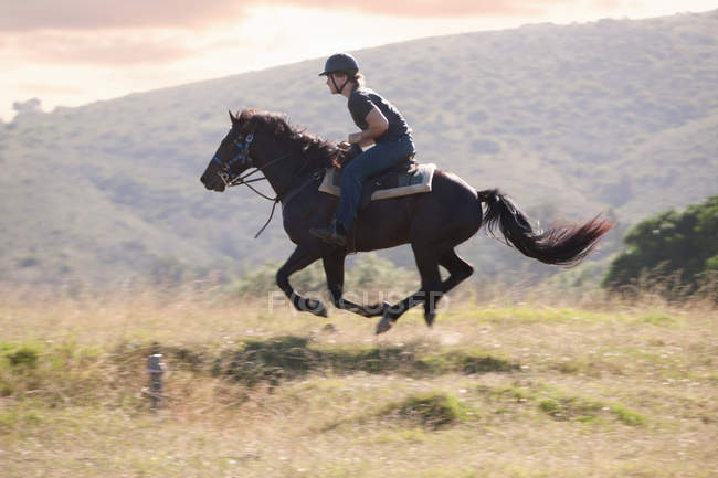 Homem montando cavalo na paisagem rural — Fotografia de Stock