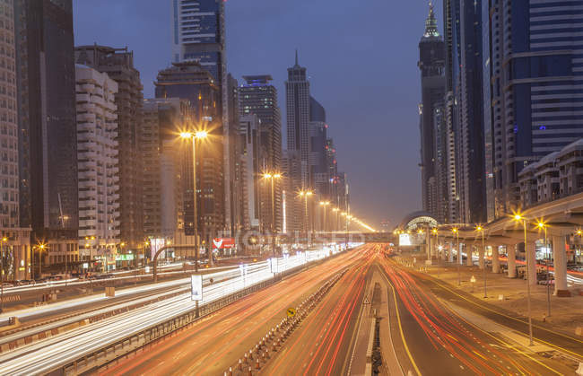 Городское шоссе и Дубайский метровокзал ночью, центр Дубая, Объединенные Арабские Эмираты — стоковое фото