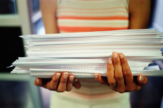 Femme portant pile de papier, gros plan — Photo de stock