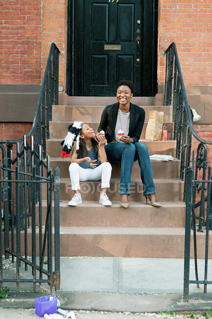 Mother and daughter eating ice cream on steps — Stock Photo