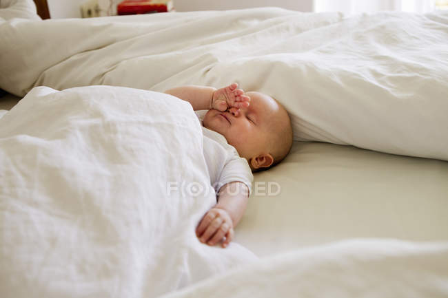 Petite fille endormie sur le lit — Photo de stock