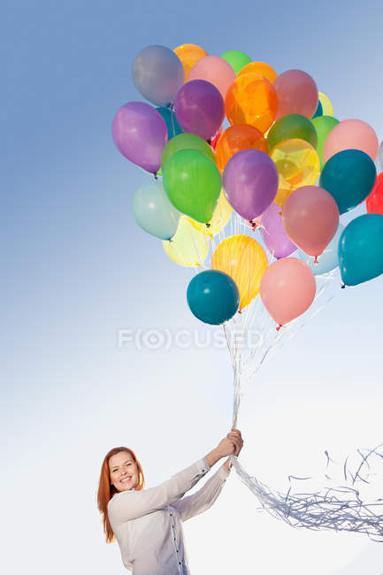 Молода жінка на відкритому повітрі з повітряними кулями — стокове фото