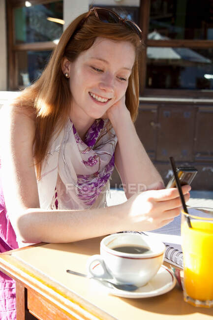 Молода жінка сидить у кафе — стокове фото