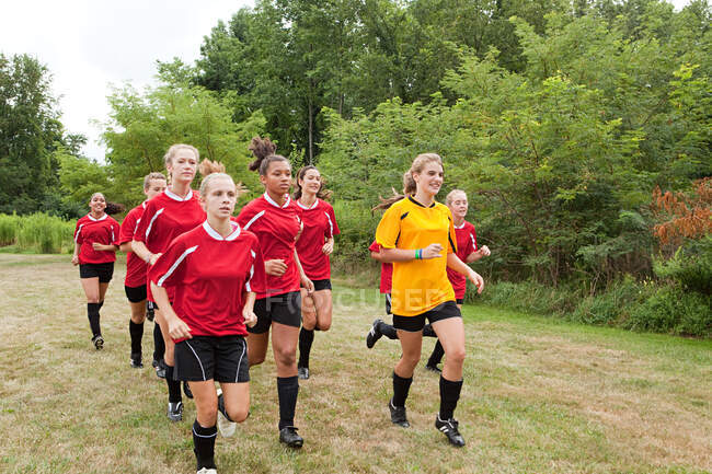 Девушки-футболисты бегут — стоковое фото
