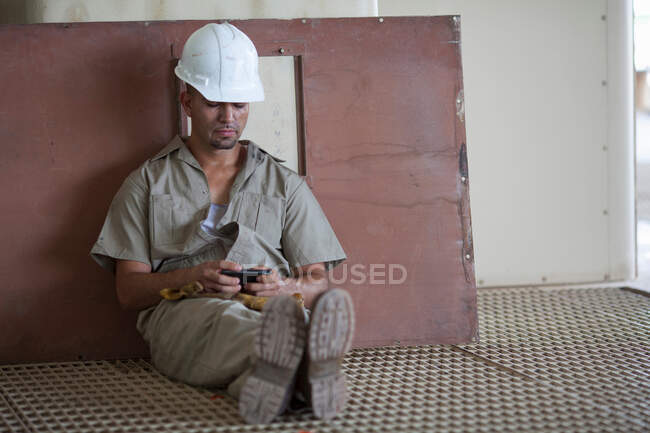 Промисловий працівник використовує мобільний телефон — стокове фото
