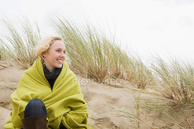 Женщина на побережье в одеяле — стоковое фото