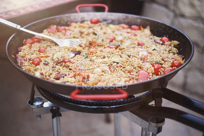 Sartén con paella fresca cocinar al aire libre - foto de stock