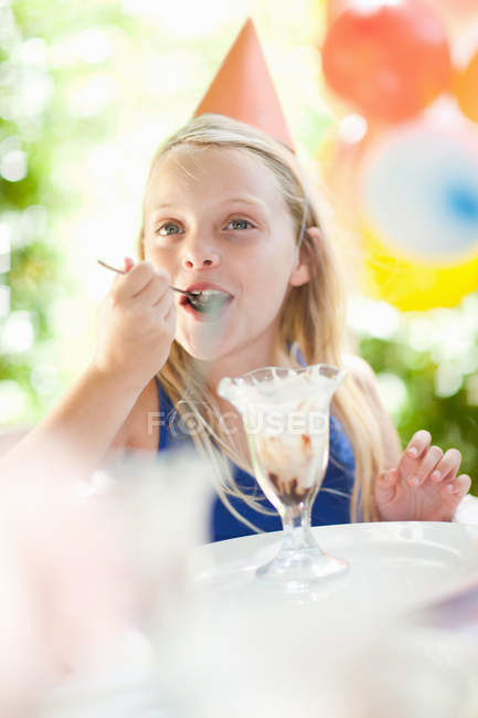 Menina que tem sorvete sundae na festa — Fotografia de Stock