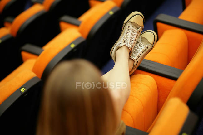Woman stretching out her legs in lecture theatre — Stock Photo
