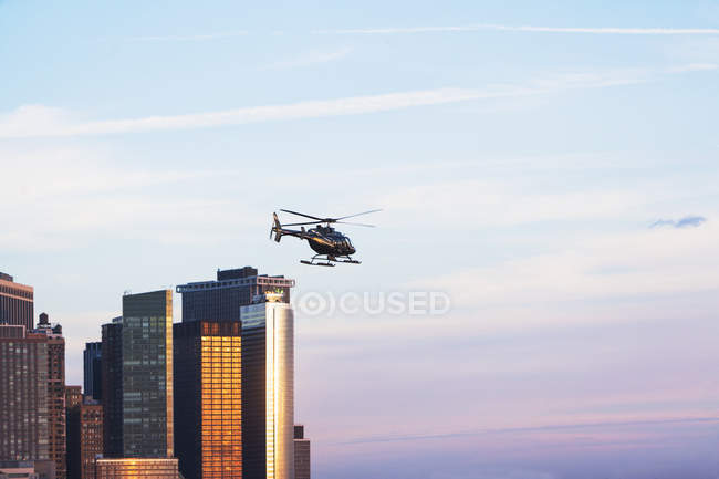Distant view of helicopter and office buildings, New York, USA — Stock Photo