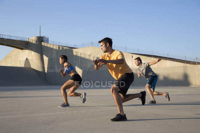 Atletas haciendo ejercicio al unísono, Van Nuys, California, EE.UU. - foto de stock