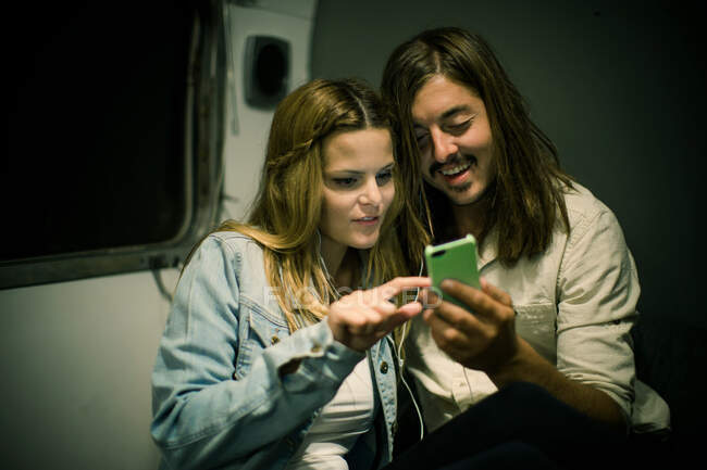 Couple listening to earphones in trailer — Stock Photo