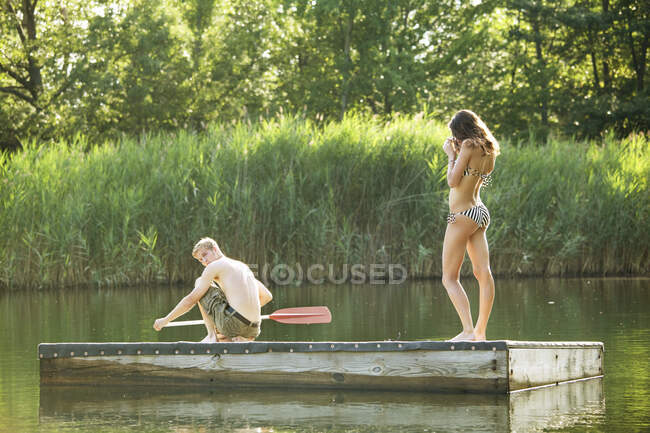 Jovem casal de pé na plataforma no rio — Fotografia de Stock