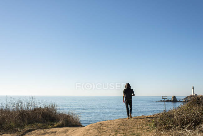 Мужчина прогуливается по пляжу на берегу моря. — стоковое фото