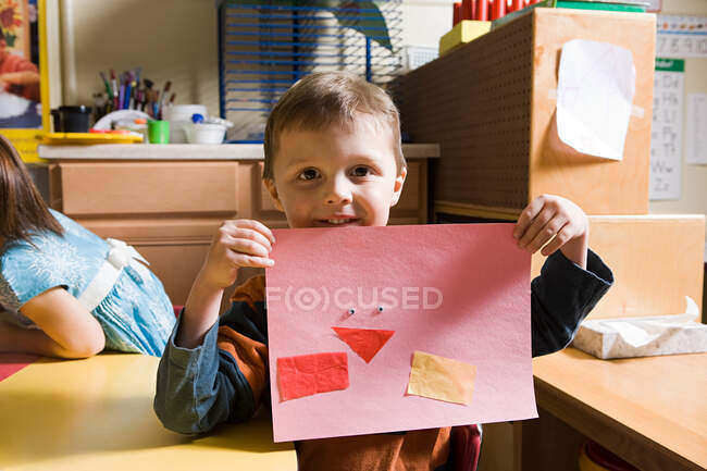 Un niño mostrando un dibujo a lápiz - foto de stock