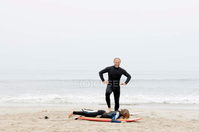 Professeur de surf plaisantant avec l'élève — Photo de stock