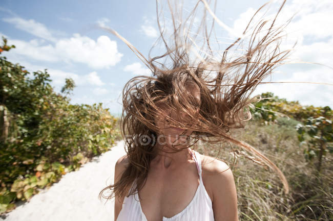Молода жінка з довгим волоссям покриває обличчя — стокове фото