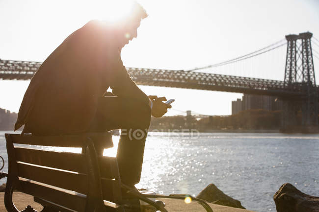 Uomo che utilizza il telefono cellulare tramite ponte urbano — Foto stock