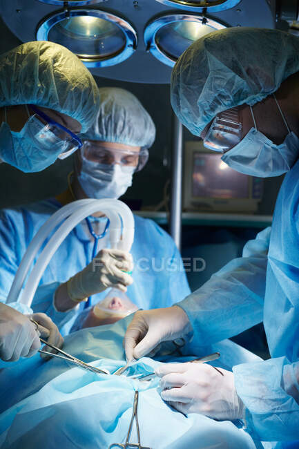 Cirujanos operando a un paciente - foto de stock