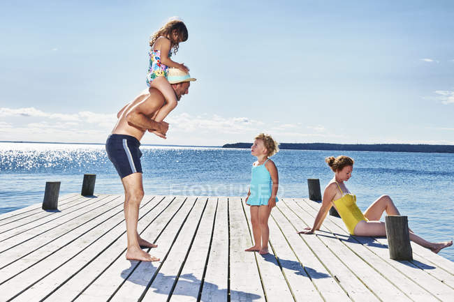 Parents and two young girls on pier — Stock Photo