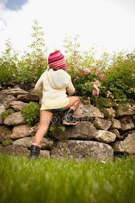 Mädchen klettert Steinmauer — Stockfoto
