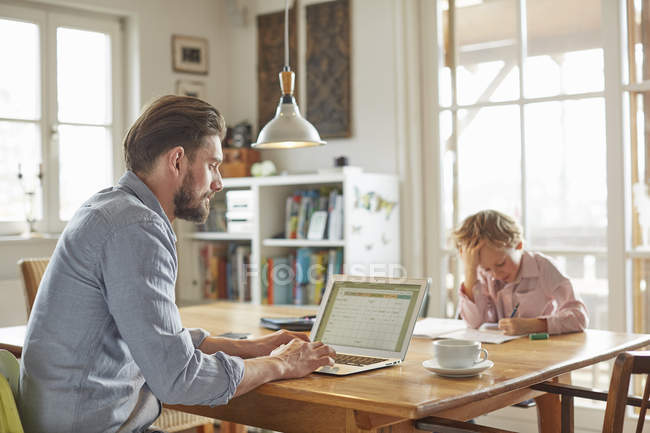 Father and son working in home office — Stock Photo