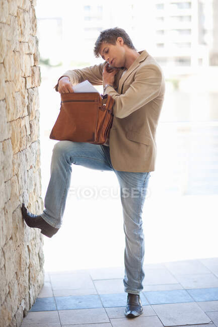 Businessman rooting through briefcase — Stock Photo