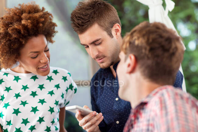 Hombre usando smartphone con amigos - foto de stock