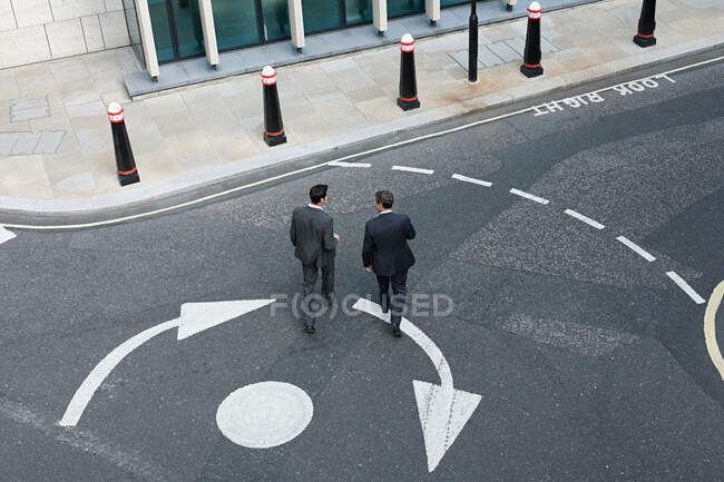 Due uomini d'affari che attraversano la strada — Foto stock