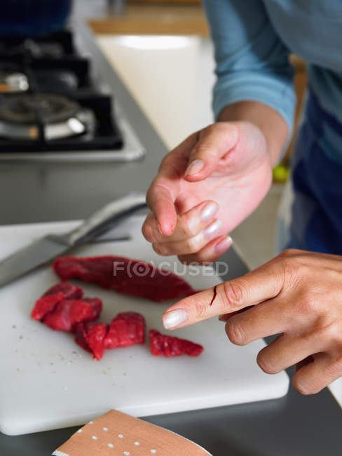 Femme dans la cuisine avec coupure au doigt — Photo de stock