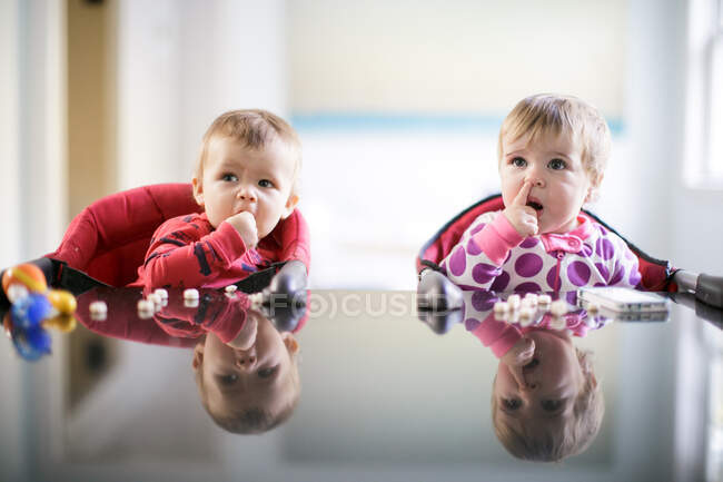 Männliche und weibliche Kleinkinder an der Küchentheke pflücken Nase und essen Süßigkeiten — Stockfoto