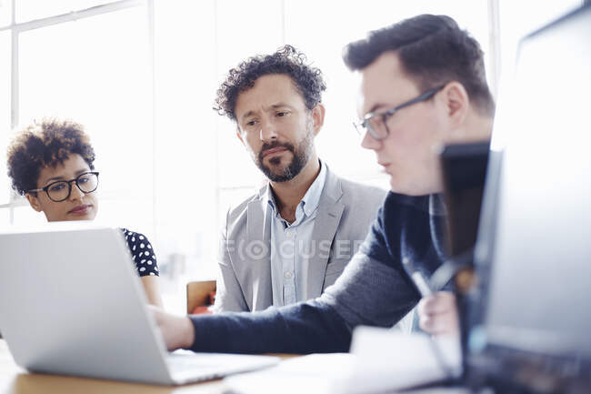 Колеги в офісі дивляться на ноутбук — стокове фото