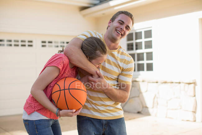 Irmão com irmã na cabeça bloqueio segurando basquete — Fotografia de Stock