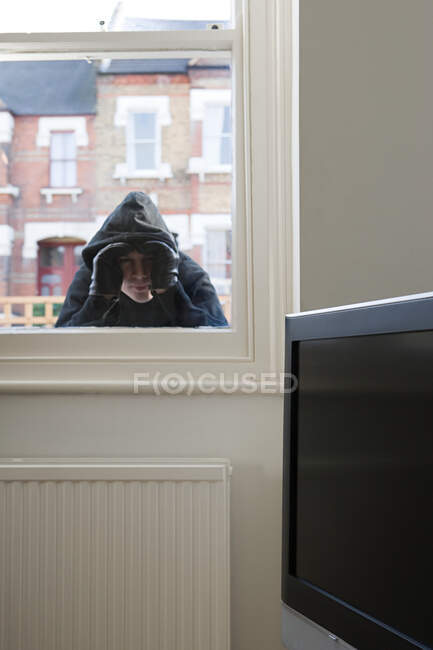 Einbrecher schaut durch Fenster — Stockfoto