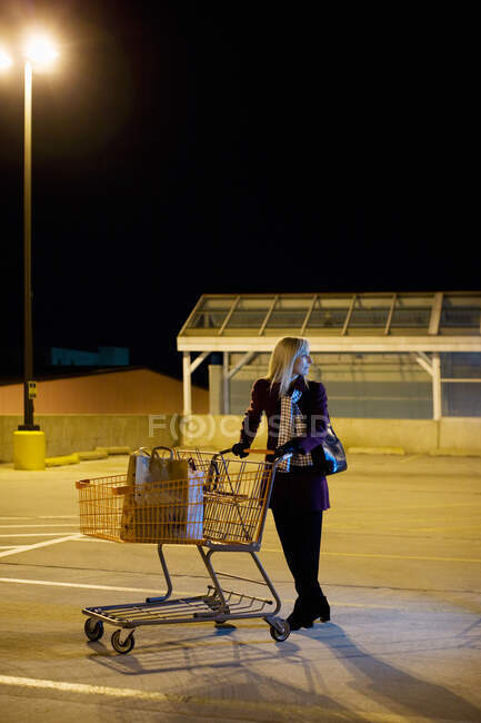 Женщина одна на парковке супермаркета — стоковое фото