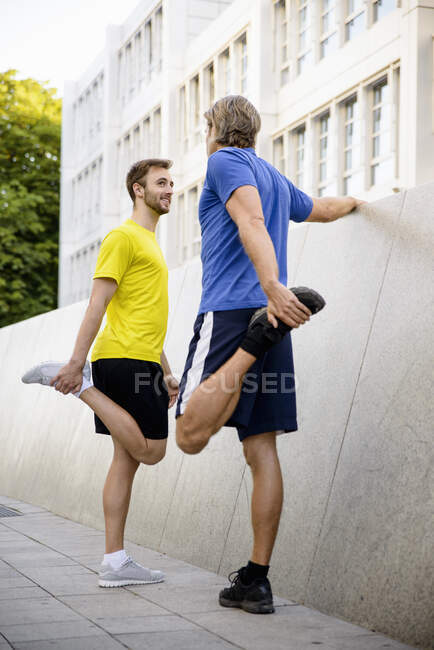 Zwei Männer dehnen Kniebeugen — Stockfoto