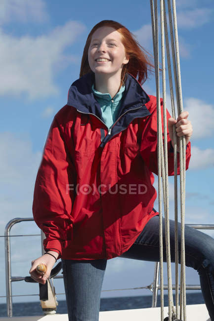 Junge Frau hält sich an Seil auf Jacht fest — Stockfoto