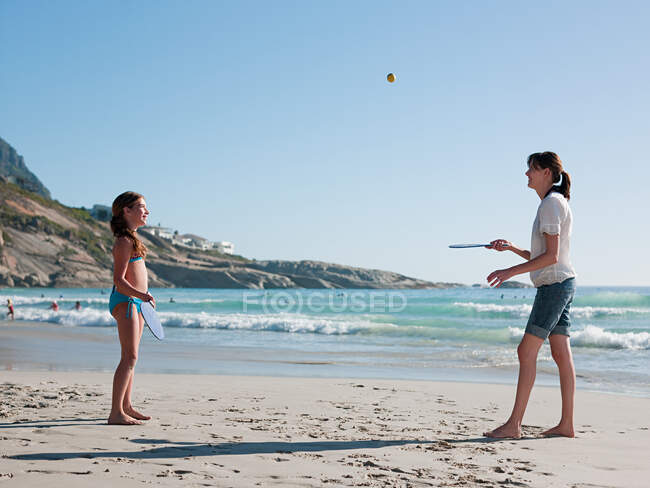 Мать и дочь играют в футбол на пляже — стоковое фото