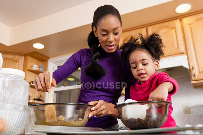 Mãe e filha misturando massa de biscoito — Fotografia de Stock
