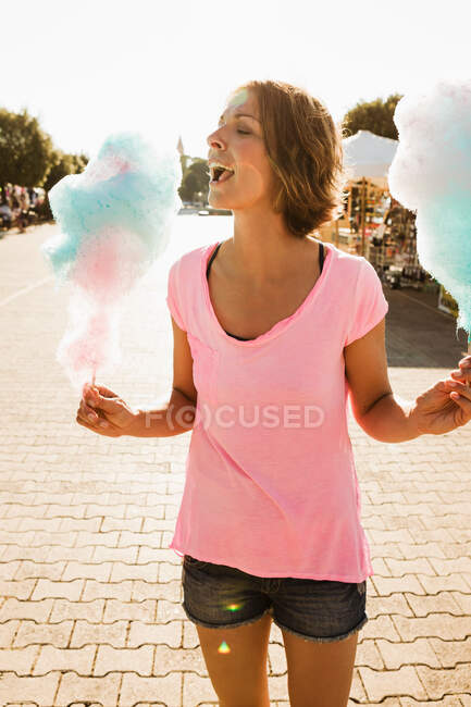 Woman eating cotton candy outdoors — Stock Photo