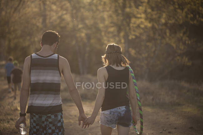 Молода пара ходить в лісі тримаючи руки — стокове фото
