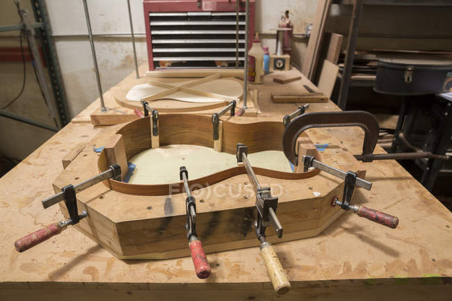 Guitare serrée sur table en atelier — Photo de stock